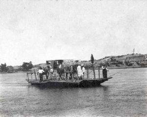 Balsa sobre el río Neuquén. Al fondo se puede ver el puente ferroviario.