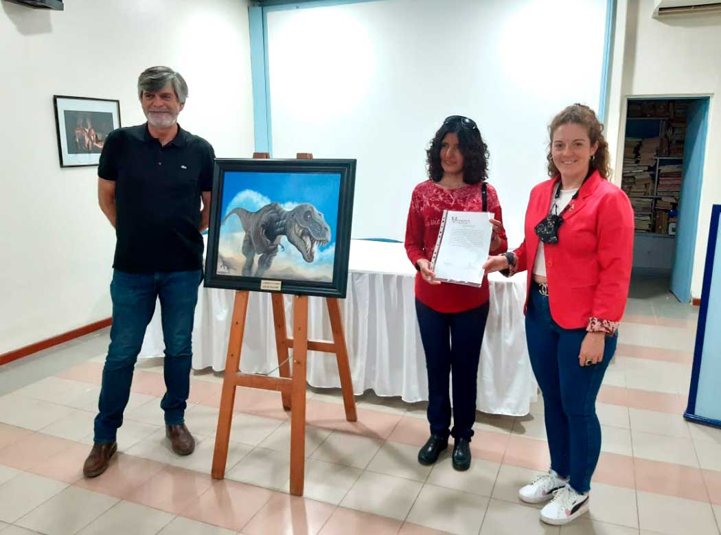 Lucía Del Valle con su obra, junto a la directora del Museo Municipal Carmen Funes de Plaza Huincul, Ludmila Coria, y el paleontólogo Rodolfo Coria.